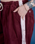 Close up of Sydney's hand in the front pocket of Painted Drop Pocket Cargo Pants in Red Wine