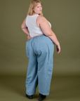 Angled back view of Denim Drop Pocket Pants in Light Wash and Cropped Tank in Vintage Tee White on Juliet