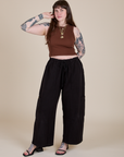 Sydney is wearing Muscle Tee in Fudgesicle Brown paired with black Drop Pocket Cargo Pants