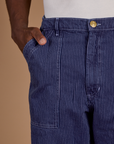 Close up of Isaac's hand in the front pocket of Railroad Denim Work Pants in Faded Grape Overdye