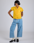 Kira is 5’10” and wearing P Pantry Button-Up in Sunshine Yellow paired with light wash Denim Drop Pocket Pants