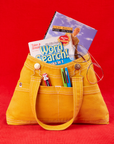 Overall Handbag in Mustard Yellow with two books inside main compartment of bag