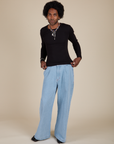 Jerrod is wearing Long Sleeve Baby Tee in Basic Black and light wash Indigo Wide Leg Trousers