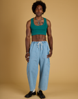 Jerrod is wearing Contrast Stitch Mini Tank in Hunter Green and light wash Denim Drop Pocket Pants