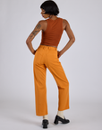 Back view of Work Pants in Creamsicle Orange and burnt terracotta Cropped Tank on Kira