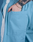 Close up of Sydney's hand in the back pocket of Painted Drop Pocket Cargo Pants in Baby Blue