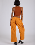 Back view of Drop Pocket Cargo Pants in Creamsicle Orange and burnt terracotta Cropped Tank on Kira