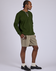 Angled front view of Pleated Trouser Shorts in Khaki Grey and evergreen Long Sleeve Burly Tee on Jerrod