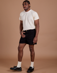 Angled front view of Classic Work Shorts in Basic Black and Organic Vintage Tee in Vintage Off White on Isaac