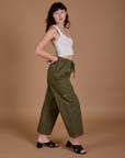 Side view of Drop Pocket Cargo Pants in Surplus Green and Cropped Tank in vintage tee white on Alex