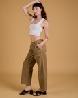 Side view of Baggy Mid-Rise Trousers in Desert Brown and vintage tee white Cropped Tank on Alex