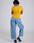 Back view of Jr. Varsity Tee in Sunshine Yellow and light wash Denim Drop Pocket Pants on Kira