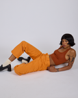 Kira is wearing Work Pants in Creamsicle Orange and burnt terracotta Cropped Tank