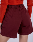 Pleated Trouser Shorts in Red Wine back view close up on Alex