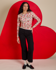 Shahana is wearing Long Sleeve Baby Tee in Hot Stuff Print tucked into black Western Pants