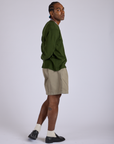 Side view of Pleated Trouser Shorts in Khaki Grey paired with evergreen Long Sleeve Burly Tee