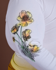 Close up of screen-print flowers on sleeve of Floral Long Sleeve Baby Tee in Yellow