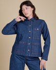 Alex is wearing a buttoned up Indigo Denim Work Jacket in Dark Wash
