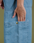 Close up of Anjaline's hand in the pant leg side pocket of Denim Drop Pocket Pants in Light Wash