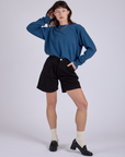 Alex is wearing Pleated Trouser Shorts in Basic Black and Long Burly Tee in French Blue