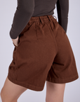 Pleated Trouser Shorts in Fudgesicle Brown back view close up on Alex