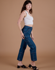 Side view of Carpenter Jeans in Dark Wash and Cropped Tank in Vintage Tee White on Alex