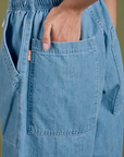 Close up of Anjaline's hand in the back pocket of Denim Drop Pocket Pants in Light Wash