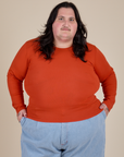 Sam is 5’10” and wearing XL Long Sleeve Baby Tee in Chili Red