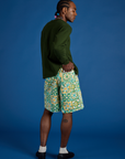 Angled back view of Longline Work Shorts in Spring Quilt Print and evergreen Long Sleeve Burly Tee