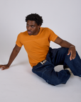 Jr. Varsity Tee in Creamsicle Orange and dark wash Denim Drop Pocket Pants worn by Isaac