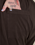 Close up of Sam's hand in the back pocket of Short Sleeve Jumpsuit in Espresso Brown