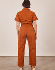 Back view of Short Sleeve Jumpsuit in Burnt Terracotta worn by Tiara