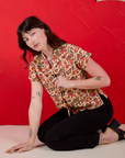 Alex is wearing Hot Stuff Print Pantry Button-Up paired with black Western Pants