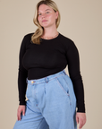Lish is wearing Long Sleeve Baby Tee in Basic Black tucked into light wash Indigo Wide Leg Trousers