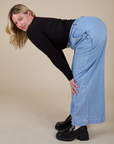 Side view of Long Sleeve Baby Tee in Basic Black and light wash Wide Leg Trousers