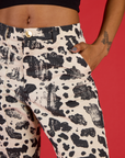 Close up of Kira's hand in the front pocket of the Cow Work Pant
