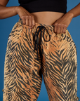 Close up of Kira's hands on the waistband of the Tiger Drop Pocket Pant