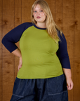 Juliet wearing the Gross Green/Navy Colorblock Raglan Tee untucked