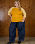 Juliet wearing the Mustard Yellow/Butter Raglan Tee untucked with Dark Wash Denim Drop Pocket Pants
