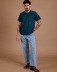 Jesse is wearing Burly Tee in Lagoon paired with light wash Carpenter Jeans