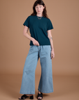 Alex is 5'8" and wearing P Burly Tee in Lagoon paired with light wash Indigo Wide Leg Trousers