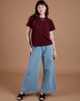 Alex is wearing Burly Tee in Red Wine and light wash Indigo Wide Leg Trousers