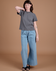 Alex is 5'8" and wearing P Burly Tee in Washed Grey paired with light wash Indigo Wide Leg Trousers