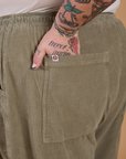 Close up of Sam's hand in the back pocket of Corduroy Drop Pocket Cargo Pants in Khaki Grey