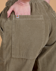 Close up of Alex's hand in the back pocket of Corduroy Drop Pocket Cargo Pants in Khaki Grey