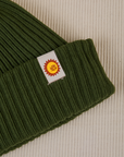 Ribbed Beanie in Evergreen close up of sun baby tag