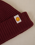 Ribbed Beanie in Red Wine close up of sun baby tag