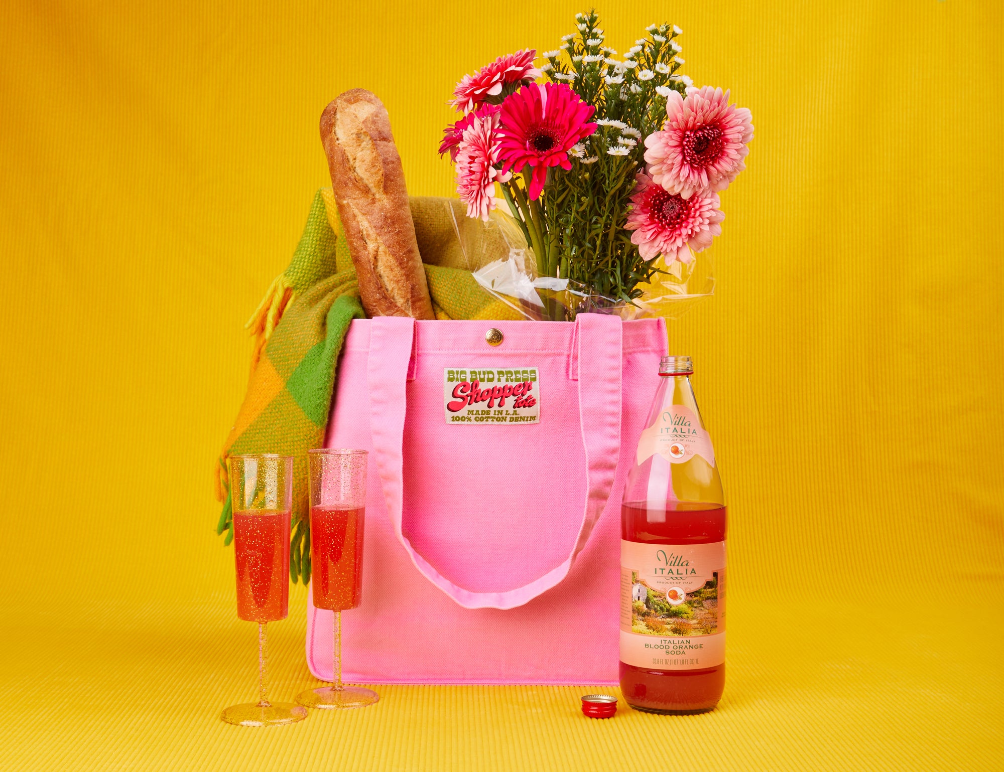 Shopper Tote in Sunshine Yellow filled with lettuce, celery and radishes. Peppers and garlic placed in front of the bag
