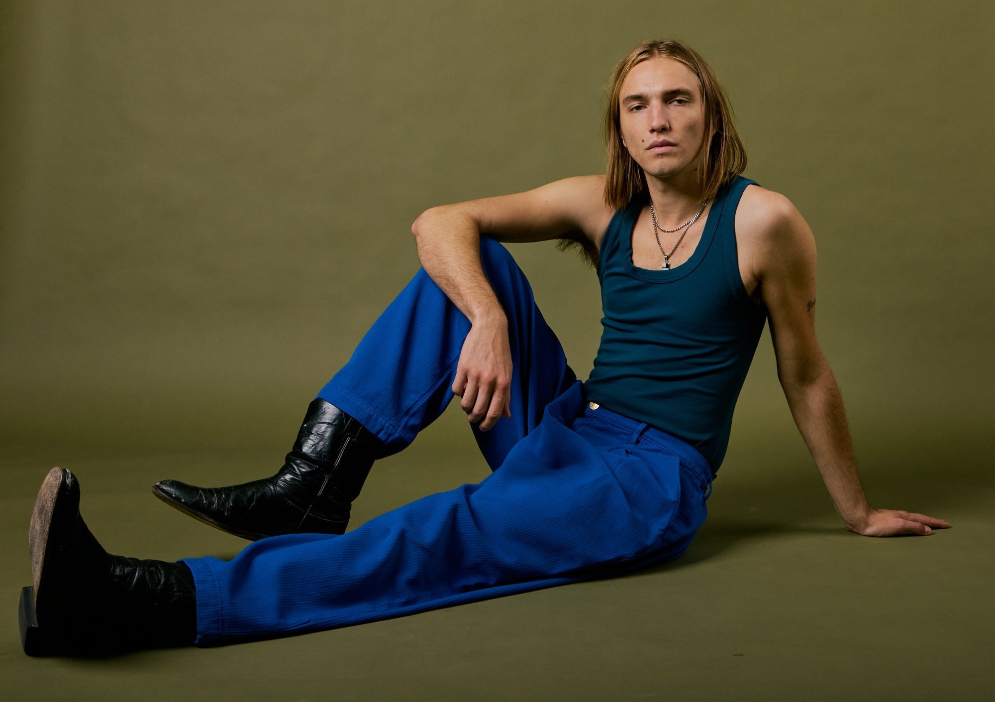 Grant is wearing Heritage Trousers in Royal Blue and Tank Top in Lagoon