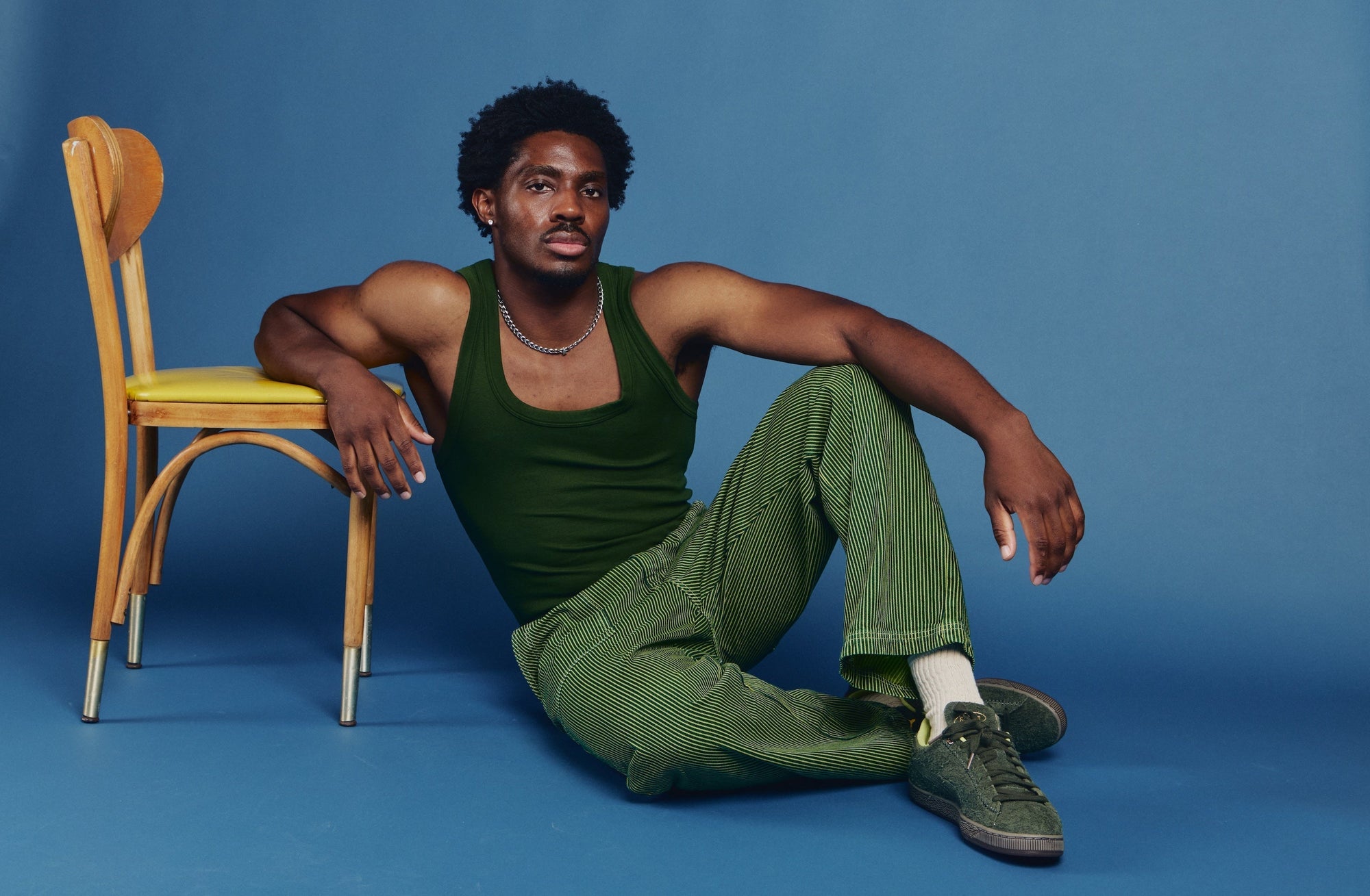 Isaac is wearing Railroad Denim Work Pants in Gross Green Overdye and Tank Top in Swamp Green